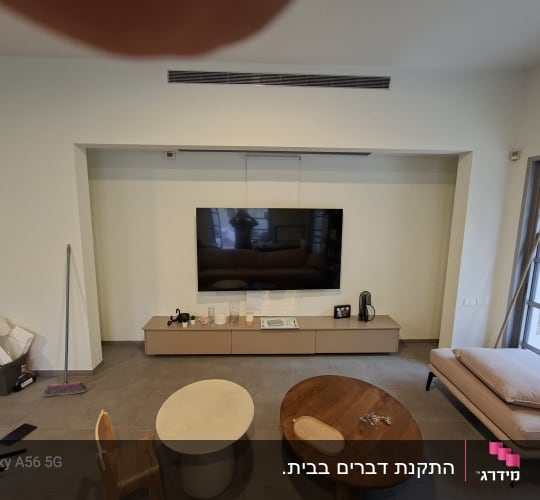 תליית טלוויזיה שטוחה על קיר בסלון מעל מזנון